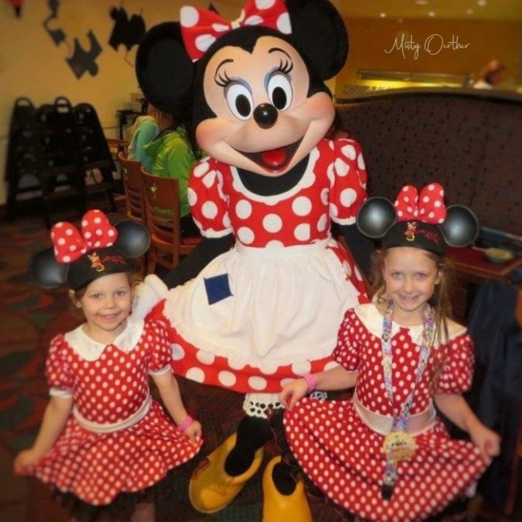 minnie mouse and two girls in matching dresses